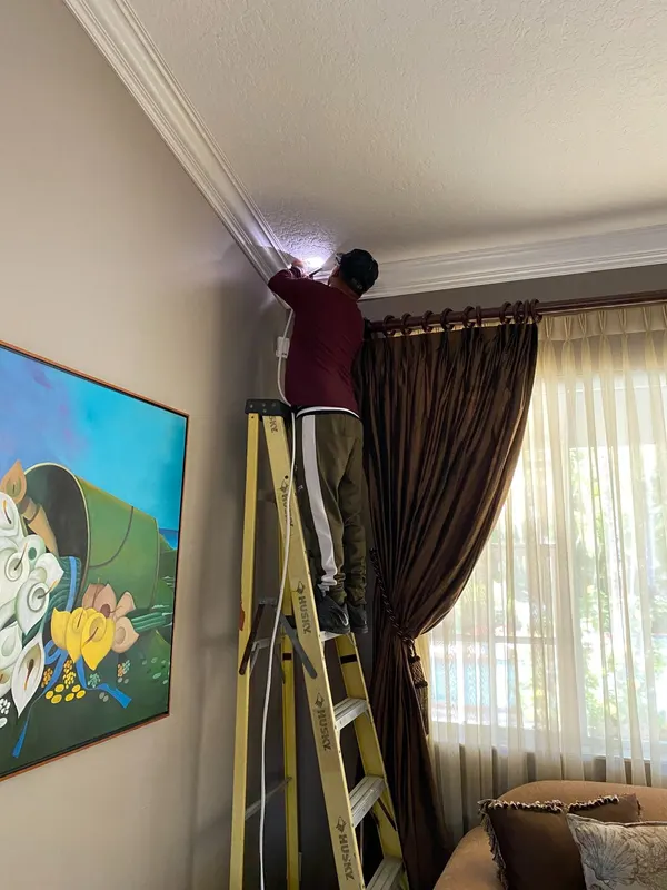 Technician installing an indoor security camera in a Miami home