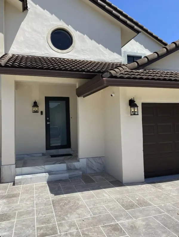 Discreet camera beside the entrance and garage of a Miami Lakes home
